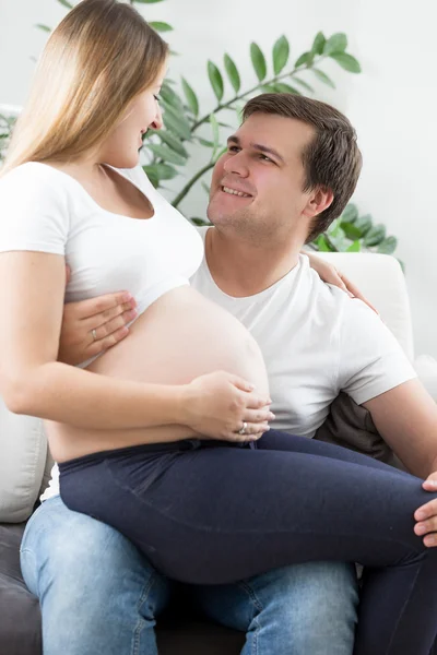 Felice uomo abbracciare e guardando la moglie incinta — Foto Stock