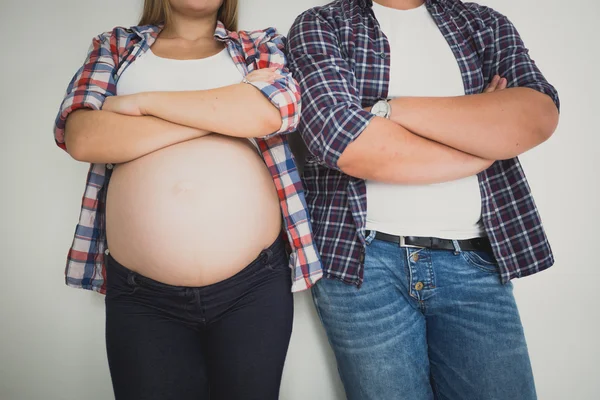 Closeup photo of pregnant woman and husband leaning on white wal — Stock Photo, Image