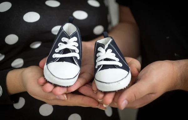准父母手上拎着婴儿靴子的特写 — 图库照片