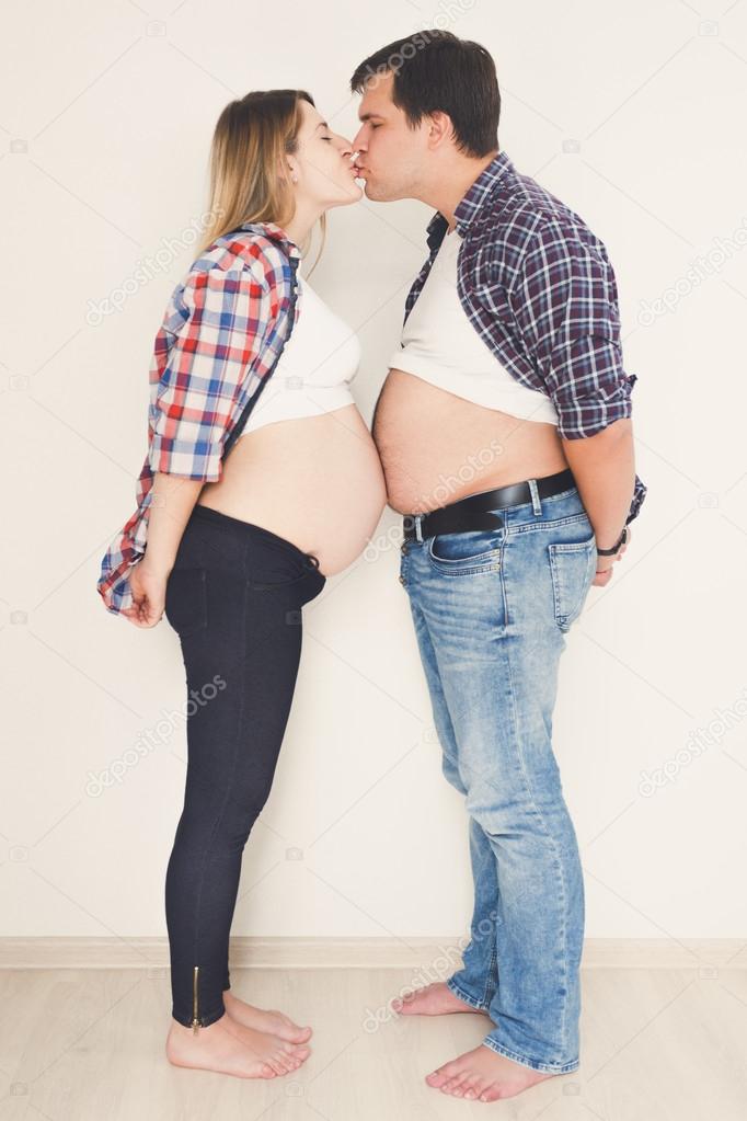 Funny portrait of pregnant couple standing face to face and kiss Stock  Photo by ©Kryzhov 98300442
