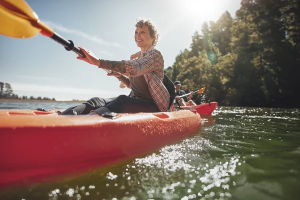 Woman canoeing in lake with man — Stock Photo, Image