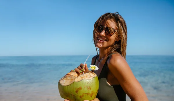 Kobieta ze świeżego kokosa na plaży — Zdjęcie stockowe