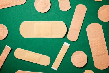 Close-up of some plasters on a green table. clipart