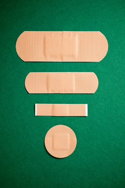 Close-up of some plasters on a green table.