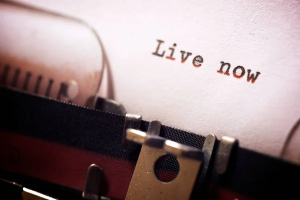 Live now phrase written with a typewriter.