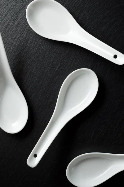 Four Small White Spoons Black Slate Table — Stock Photo, Image