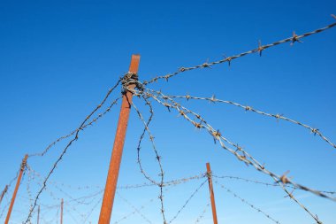 Paslı dikenli tellerin yakınına..