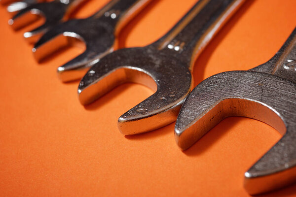 Wrenches on a orange table.