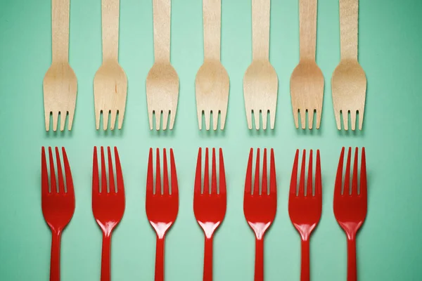 Disposable wooden and plastic cutlery on a table.