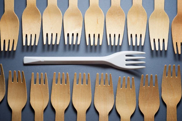 Disposable wooden and plastic cutlery on a table.