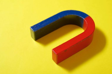 Sarı bir masada at nalı mıknatısı.