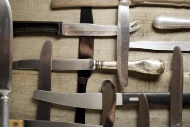 Tahta bir masada bıçak koleksiyonu..