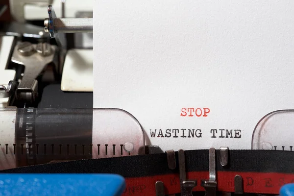 Stop wasting time phrase written with a typewriter.