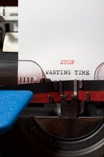 Stop wasting time phrase written with a typewriter.