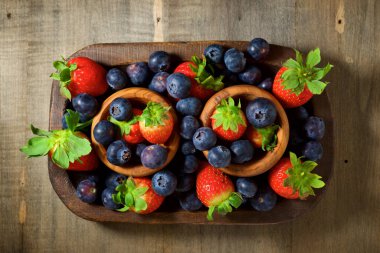 Tahta kaselerde çilek ve yaban mersini..