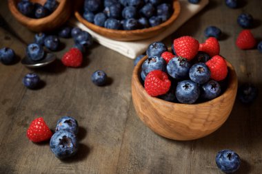 Ahşap kaselerde ahududu ve yaban mersini.