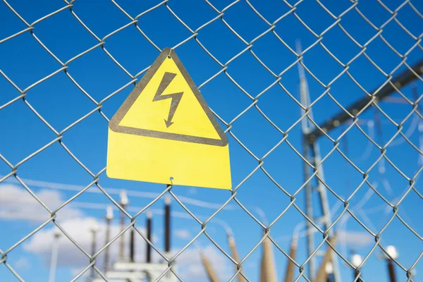 Electrical hazard sign placed on a metal fence.