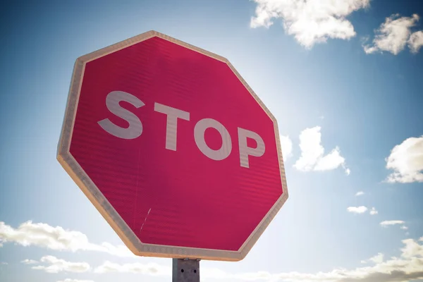 Stop traffic sign with cloudy sky.
