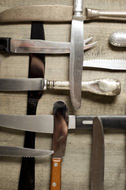 Tahta bir masada bıçak koleksiyonu..