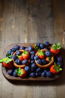 Tahta kaselerde çilek ve yaban mersini..