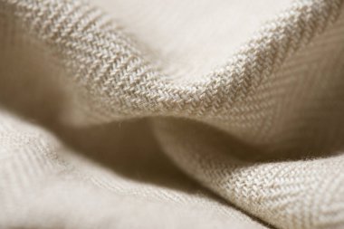 Bej renkli bir kumaşın yakın çekimi.