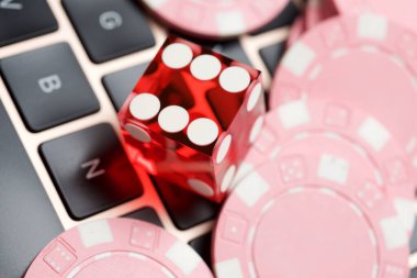 Kumarhane çipleri ve zarları dizüstü bilgisayarda..