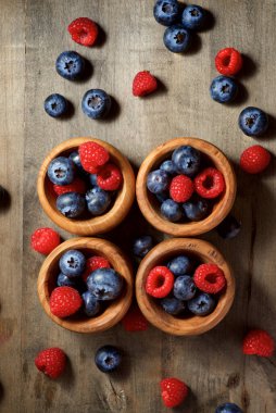 Ahşap kaselerde ahududu ve yaban mersini.