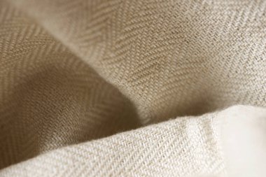 Bej renkli bir kumaşın yakın çekimi.
