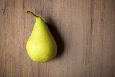 Ahşap bir masanın üzerindeki armudun yakın çekimi..