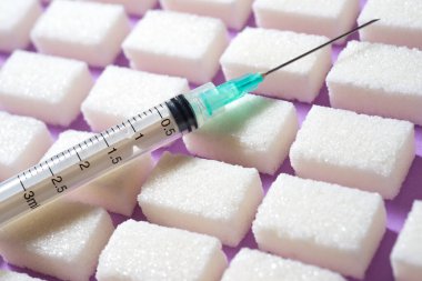 Şeker küpleri ve şırınga masanın üstünde..