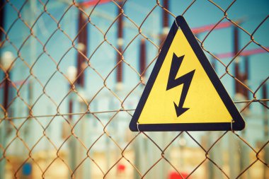 Elektriksel tehlike işareti metal bir çite yerleştirilmiş..