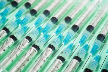 Yeşil bir masanın üzerindeki bir grup şırıngayı kapat..