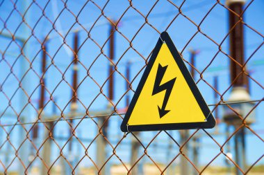 Elektriksel tehlike işareti metal bir çite yerleştirilmiş..
