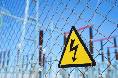 Elektriksel tehlike işareti metal bir çite yerleştirilmiş..