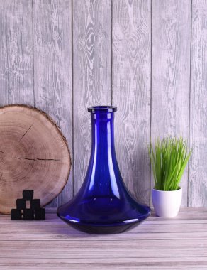 Yeşil çimen ve hindistan cevizi kömürü olan tahtalardan oluşan mavi matara.