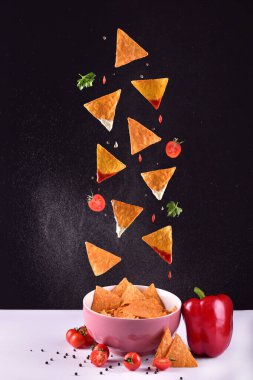 Siyah zemin üzerinde patates cipsi ve sos.