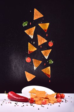 Siyah zemin üzerinde patates cipsi ve sos.