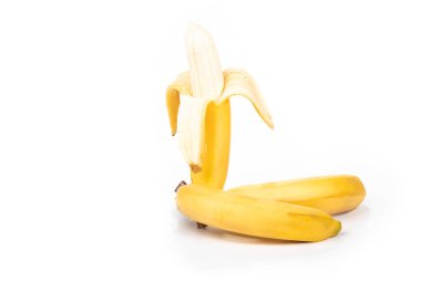 Stüdyoda çekim. Kabuktaki olgun sarı muzlardan bir dal. Beyaz arka planda. Yakın plan.