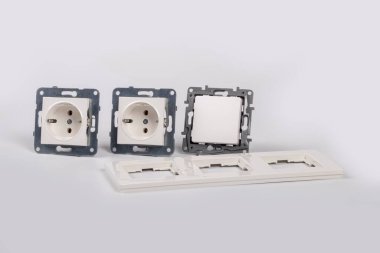 Stüdyo ışıkları. Soket ve düğme beyaz arka planda, yanında üç modül için bir çerçeve var. Yakın plan.