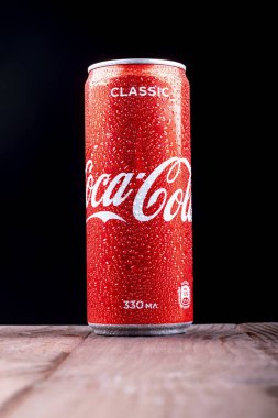 Minsk. Beyaz Rusya. 23 Ekim 2020. Stüdyo ışıkları. Kırmızı metal bir Coca-Cola kutusu boya kalemi ile kaplıdır. Soğumuş. Tahta bir arka planda duruyor Bir retro stele