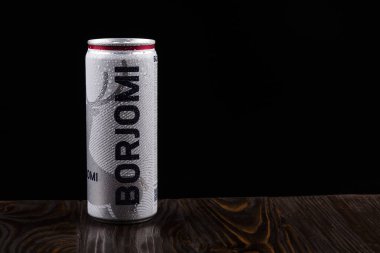 Minsk. Beyaz Rusya. 24 Ekim 2020 Stüdyo Işıklandırma. Eski bir taşın ahşap arka planında üzerinde su damlaları olan metal bir kutu var. Siyah arka plan. borjomi.