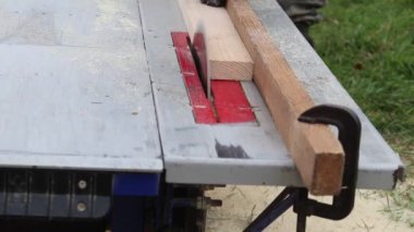 Gün ışığı. Tahta testeresi makinesi. Usta tahtayı verir. Yakın plan..