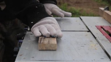 Gün ışığı. Tahta testeresi makinesi. Usta tahtayı, planlı tahtayı verir. Yakın plan..