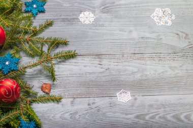 Stüdyo ışıkları. Geçmişe dönük ahşap arka plan. Üzerinde bir Noel ağacının dalları var. Yeni yılın kırmızı topları. Uzayı kopyala Mesaj at. Kar Tanesi