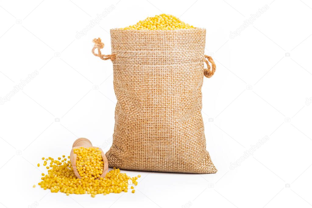 Studio lighting. White background. Close-up of cereals. Millets are placed in a wooden spice spoon. No isolation