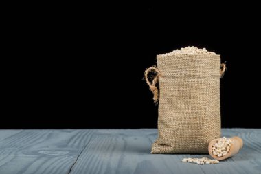 Retro tarzı ahşap arka plan. Üzerinde küçük bir torba var, arpa. Mesajın için yer aç. Boşluğu kopyala