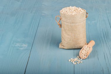 Retro tarzı ahşap arka plan. Üzerinde küçük bir torba var, arpa. Mesajın için yer aç. Boşluğu kopyala