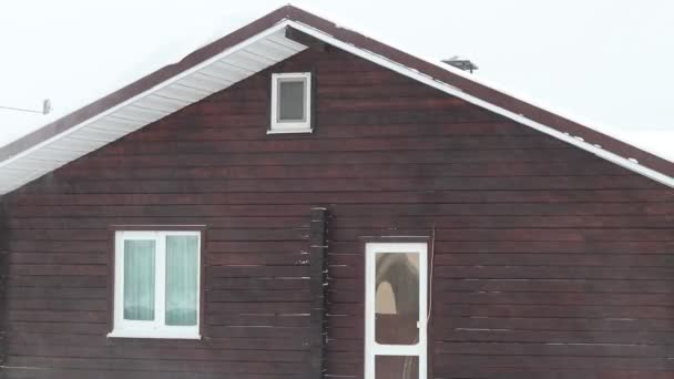 街道照明 大雪下得很大 房子的一部分是看得见的 风从屋顶刮起雪花 — 图库视频影像