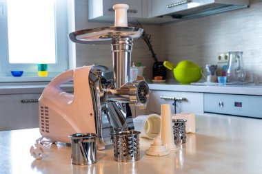 Elektrikli beyaz et öğütücüsü. Kıyma yaralıdır ve metal bir kasenin içinde yatar. Uzayı kopyala Metin.