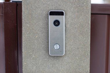 Sokak lambası. Masa betondan yapılmış. Üzerinde bir çan var. Abone ile video iletişimi sağlarName